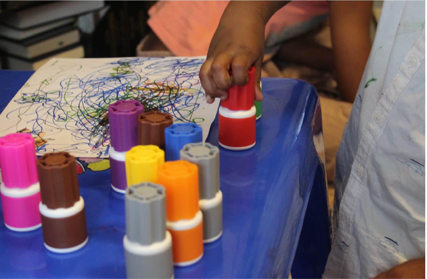 A child picking up a Sunny Marker with other Sunny Markers nearby